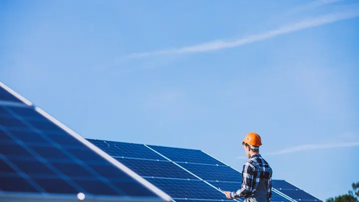 Installer fitting solar panels on a residential villa roof in Thrissur