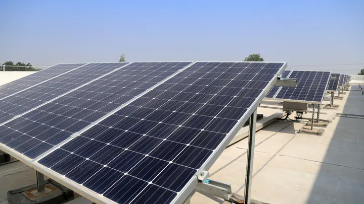 Rows of solar panels on the flat terrace of an educational institution in Kozhikode